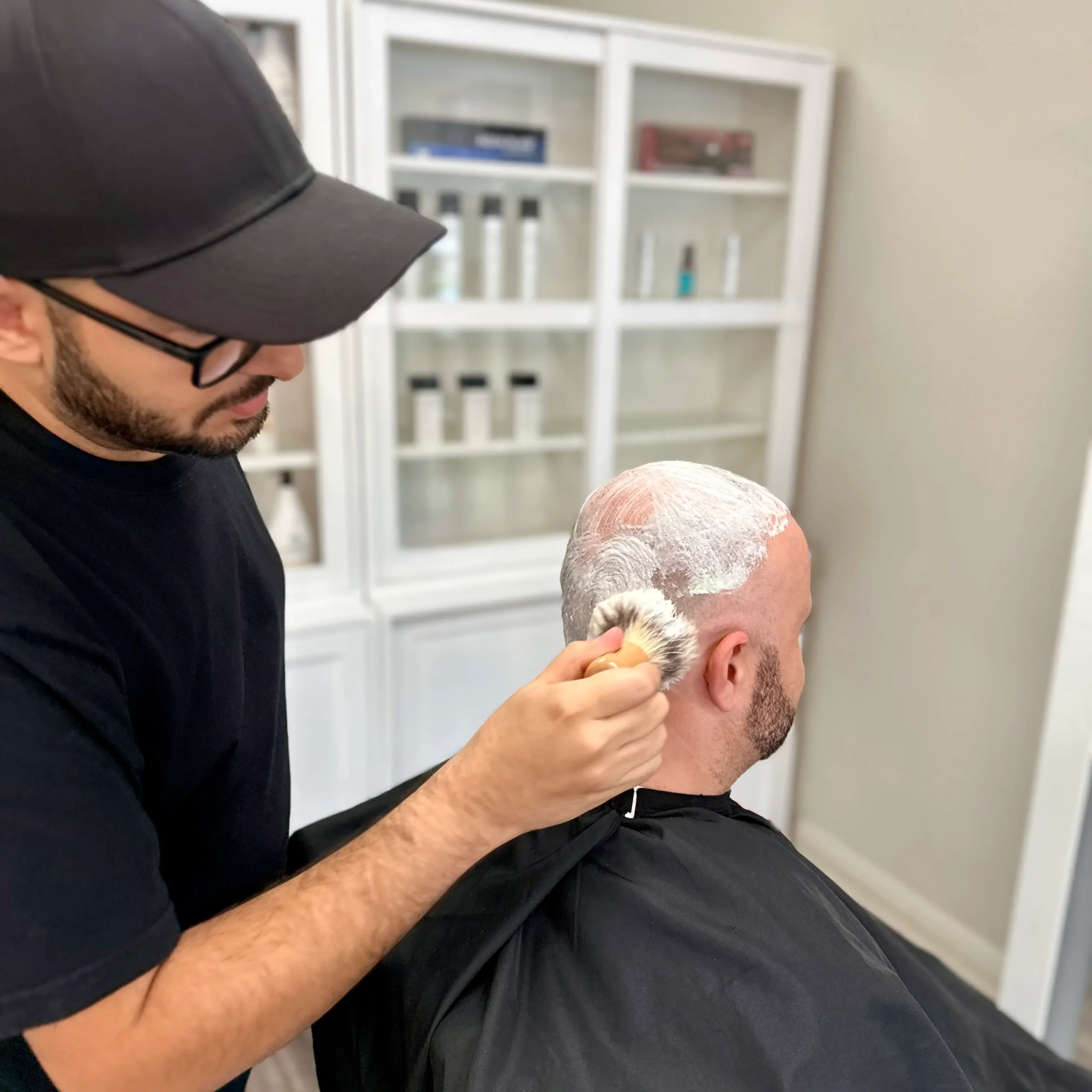 Reza Barber applying lather for a smooth head shave inside Kija Hair Salon, Irvine CA